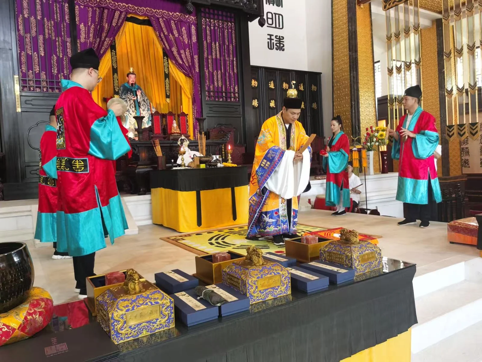 Robed Daoist practitioners gathered around an altar in a temple hall